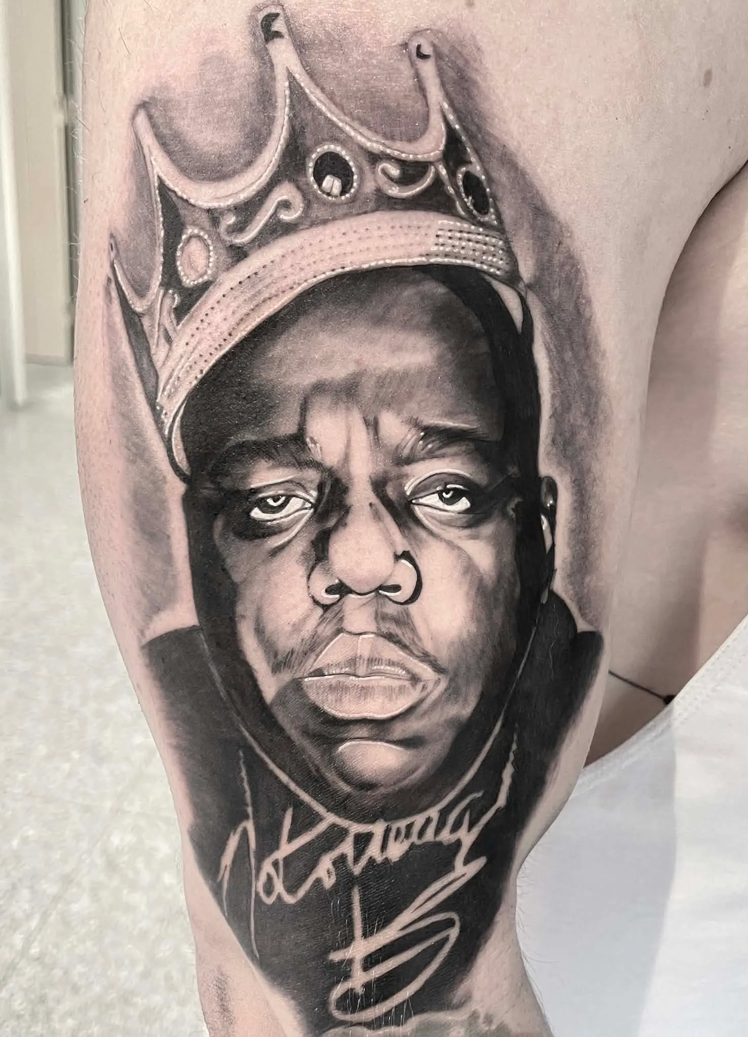 Black and grey Notorious B.I.G. portrait tattoo by Crouchy
